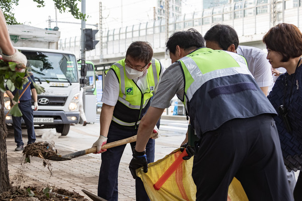 ▲ 김경호 광진구청장이 철거에 발생한 쓰레기를 삽으로 떠서 올리고 있다.